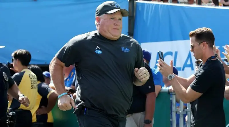 Former UCLA coach Chip Kelly running onto the field.