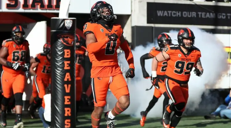 Oregon State football player run onto the field from the tunnel.