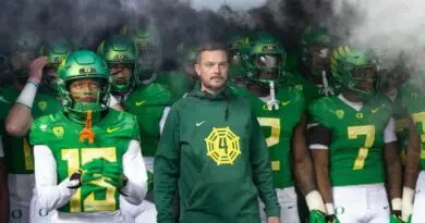 Oregon football head coach Dan Lanning with his team in the tunnel