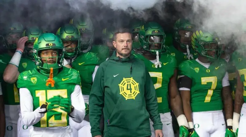Oregon football head coach Dan Lanning with his team in the tunnel
