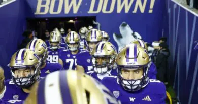 Washington Husky football players running out of Husky Stadium in Seattle