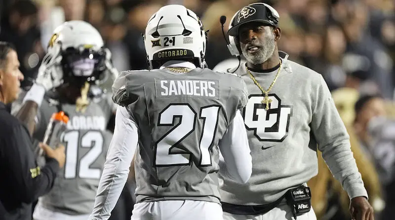 Colorado head coach Deion Sanders, right, confers with his son, safety Shilo Sanders (21), in the first half of an NCAA college football game against Cincinnati, Saturday, Oct. 26, 2024, in Boulder, Colo.