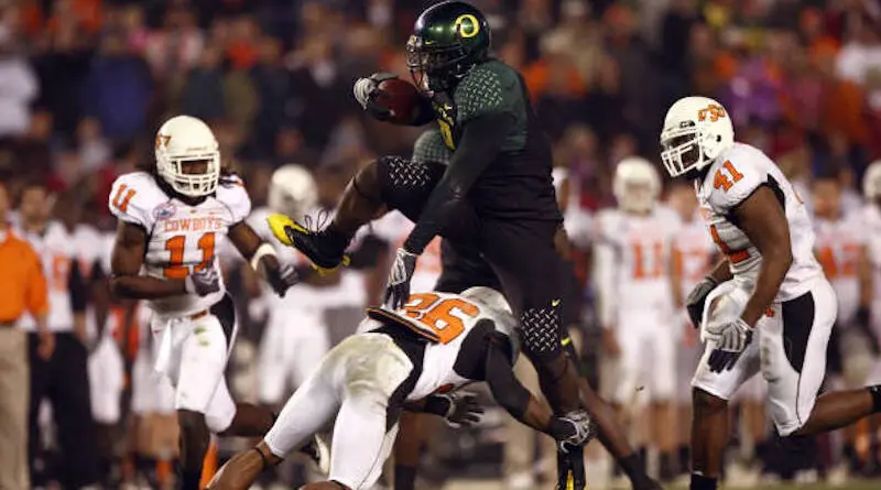 Oregon's LeGarrette Blount hurdles a Cowboy player en route to a touchdown a 42-31 win over Oklahoma State in 2008