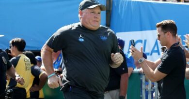 Former UCLA coach Chip Kelly running onto the field.