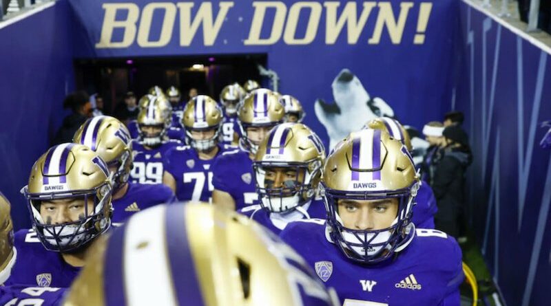 Washington Husky football players running out of Husky Stadium in Seattle