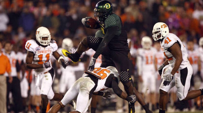 Oregon's LeGarrette Blount hurdles a Cowboy player en route to a touchdown a 42-31 win over Oklahoma State in 2008